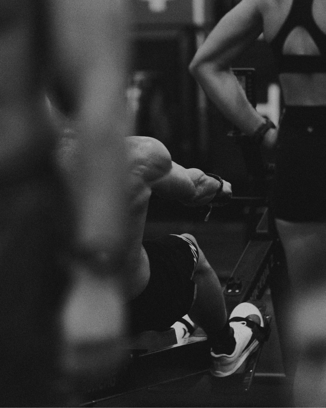 Atleta entrenando en una máquina de remo, en blanco y negro